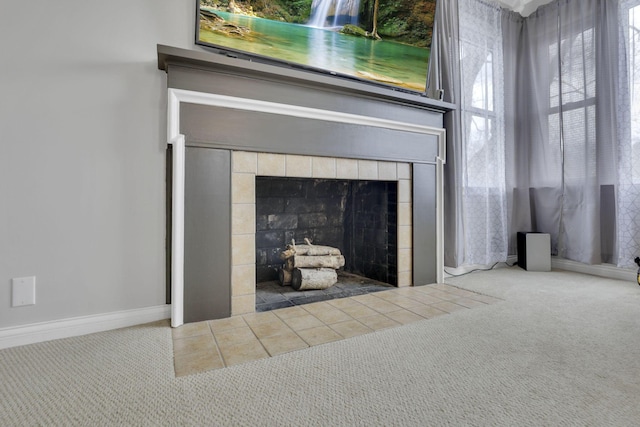 interior details featuring carpet, a tile fireplace, and baseboards