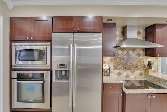 kitchen with wall chimney exhaust hood, appliances with stainless steel finishes, light stone countertops, crown molding, and backsplash