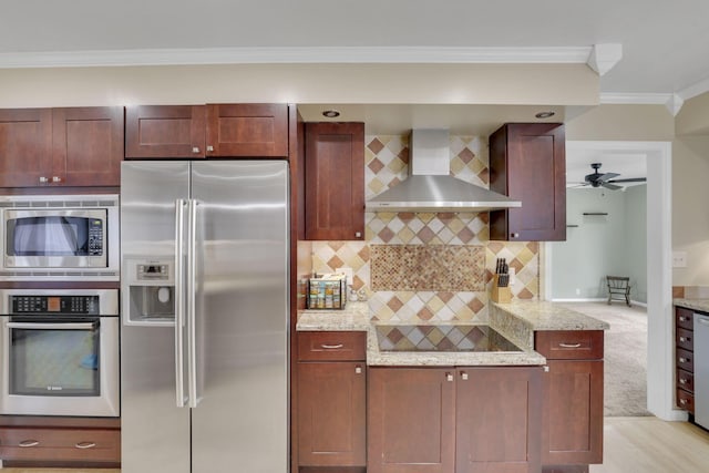 kitchen featuring tasteful backsplash, wall chimney exhaust hood, light stone counters, appliances with stainless steel finishes, and crown molding