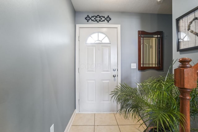 entryway featuring baseboards and light tile patterned floors