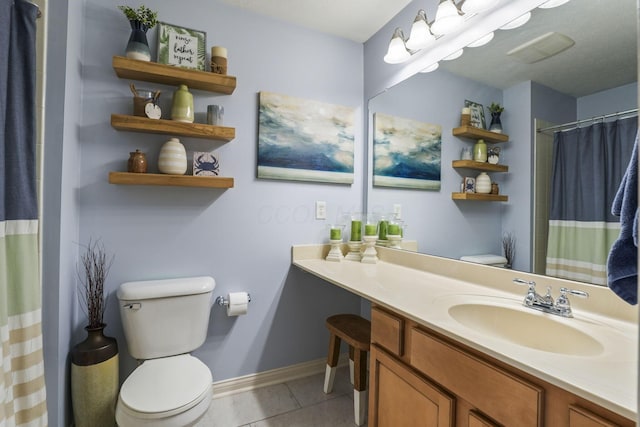 bathroom featuring vanity, tile patterned flooring, toilet, and baseboards