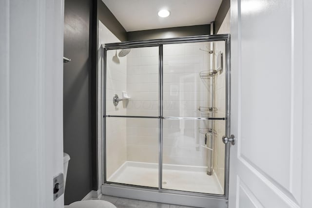 full bathroom featuring toilet and a stall shower