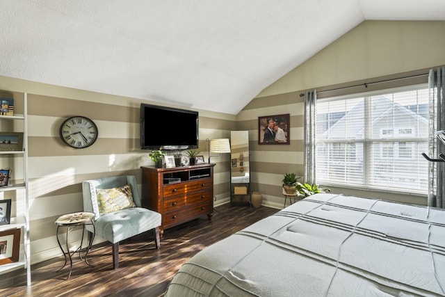 bedroom featuring lofted ceiling, baseboards, and wood finished floors