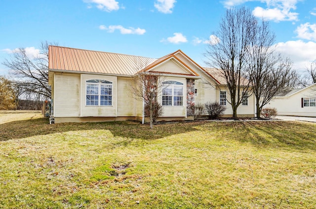 view of front of house featuring metal roof and a front yard