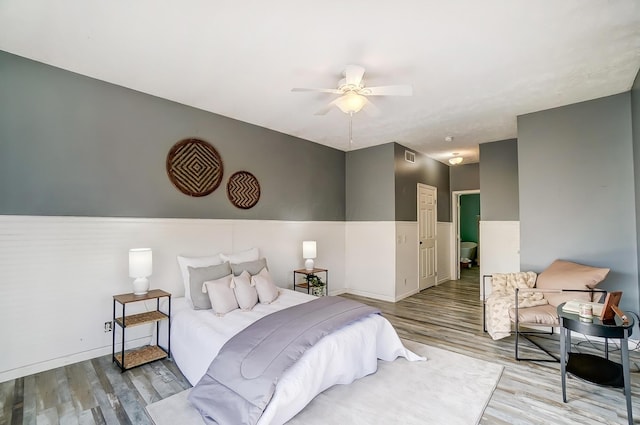 bedroom featuring baseboards, visible vents, ceiling fan, and wood finished floors