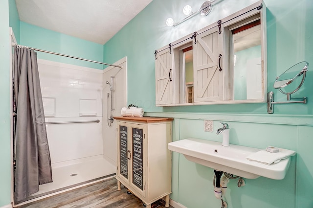 full bathroom with a shower with curtain and wood finished floors