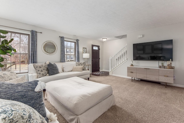 carpeted living room with stairs, a textured ceiling, and baseboards