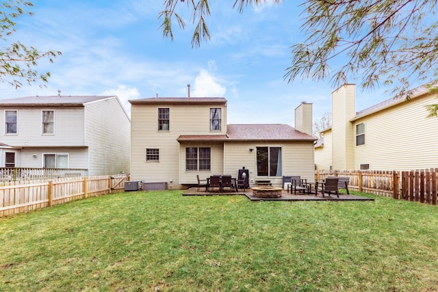 rear view of house with a lawn, a patio area, cooling unit, and a fenced backyard