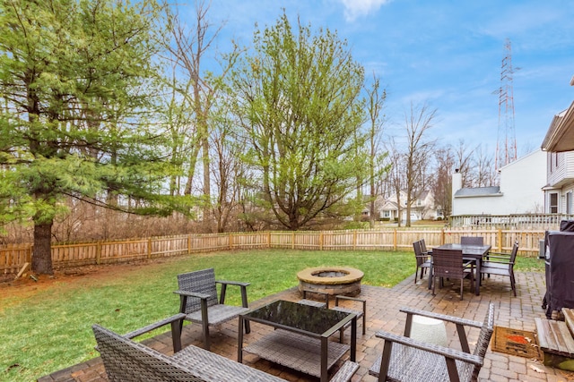 view of patio featuring an outdoor fire pit, outdoor dining area, and a fenced backyard