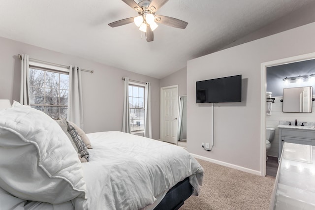 bedroom with a sink, multiple windows, vaulted ceiling, and carpet flooring