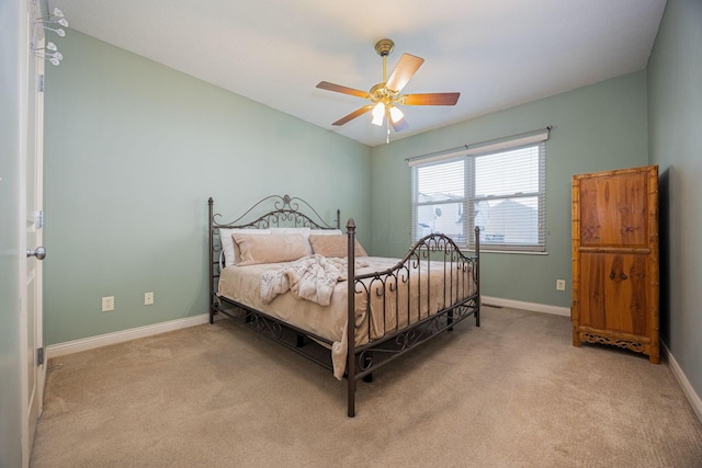 bedroom featuring light colored carpet, baseboards, and ceiling fan