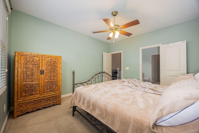 bedroom featuring carpet flooring, ceiling fan, ensuite bathroom, and baseboards