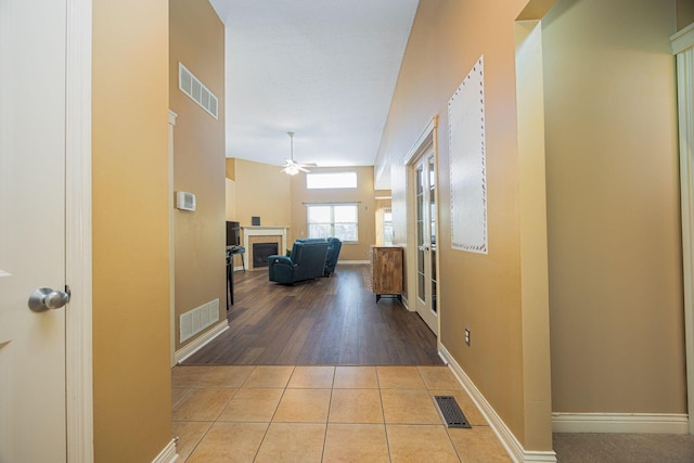 corridor with tile patterned flooring, baseboards, and visible vents