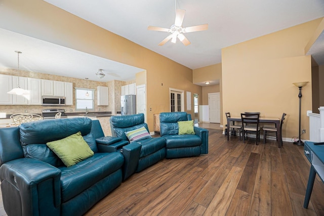 living area with dark wood-style floors, baseboards, and ceiling fan