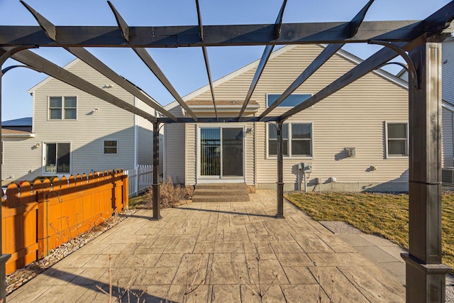 view of patio with entry steps, glass enclosure, and fence