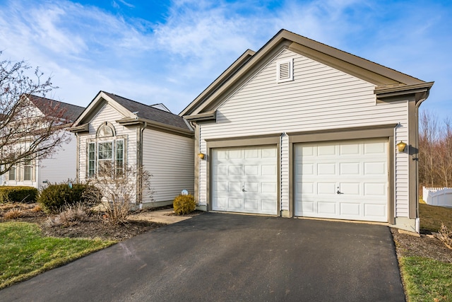 single story home featuring aphalt driveway and a garage