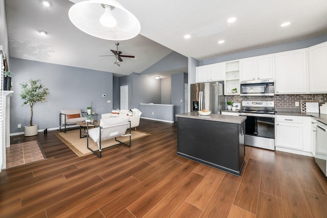 kitchen featuring open shelves, lofted ceiling, backsplash, appliances with stainless steel finishes, and a kitchen island