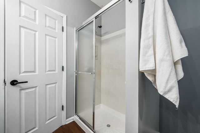 full bath with a shower stall and wood finished floors