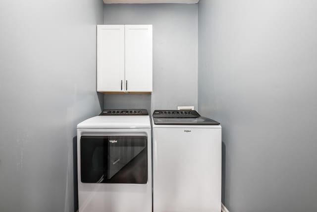 washroom with cabinet space and washer and dryer