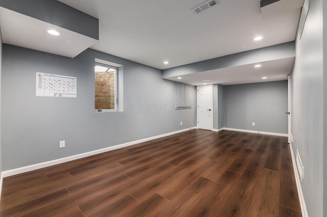 basement featuring dark wood-type flooring, recessed lighting, visible vents, and baseboards