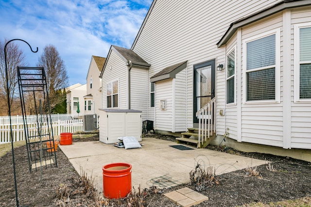 exterior space featuring entry steps, a patio, cooling unit, and fence