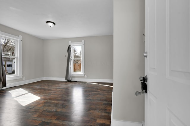 unfurnished room with wood-type flooring and baseboards