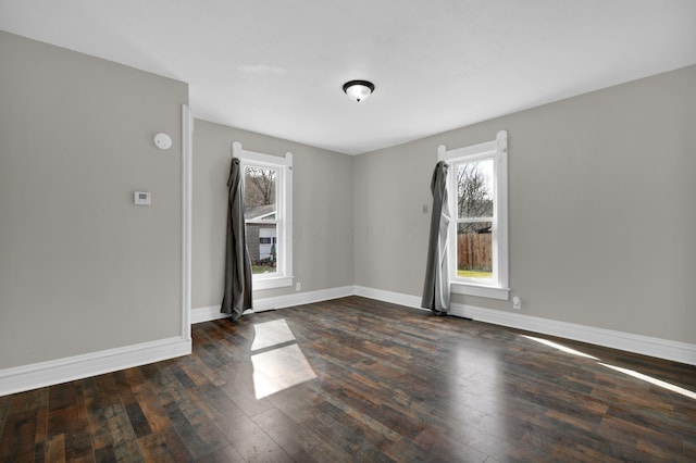 empty room with baseboards and hardwood / wood-style floors