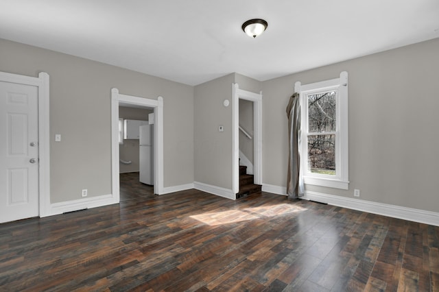 interior space featuring stairway, wood-type flooring, and baseboards