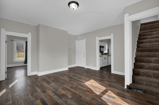 interior space featuring baseboards, visible vents, stairway, and dark wood finished floors