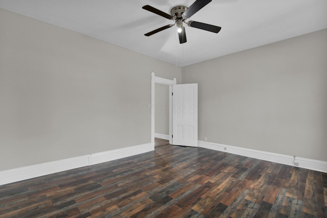 empty room featuring a ceiling fan, dark wood finished floors, and baseboards