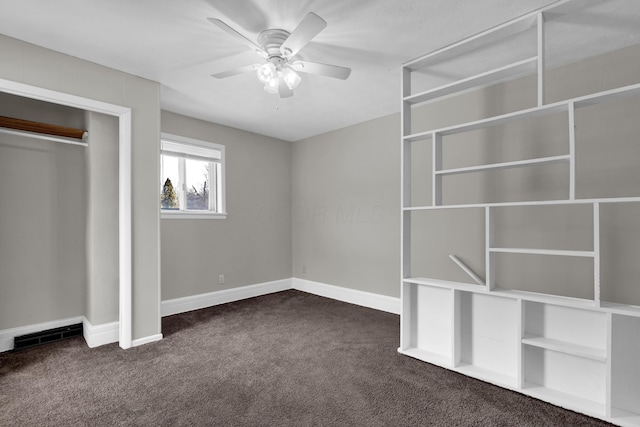 unfurnished bedroom featuring dark colored carpet, a ceiling fan, visible vents, and baseboards