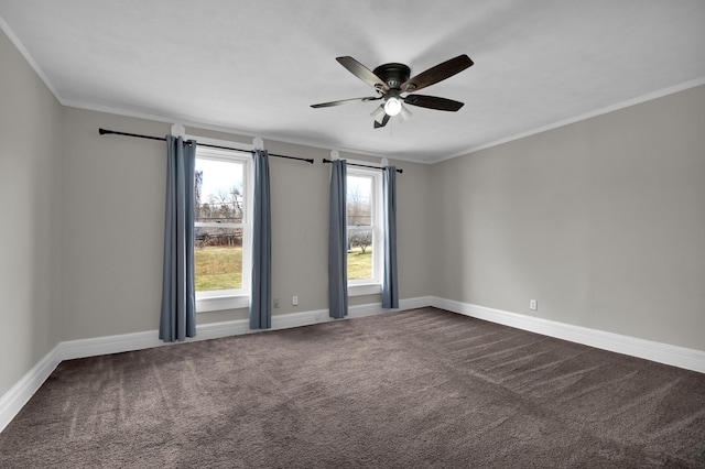 spare room with crown molding, dark carpet, baseboards, and ceiling fan