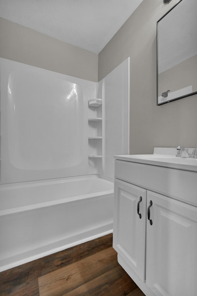 full bath featuring  shower combination, wood finished floors, and vanity