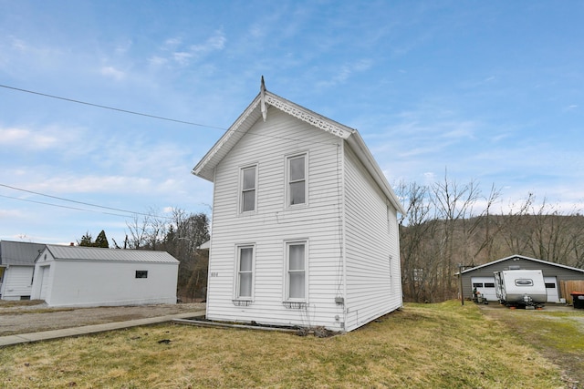 view of front facade featuring an outbuilding and a front lawn