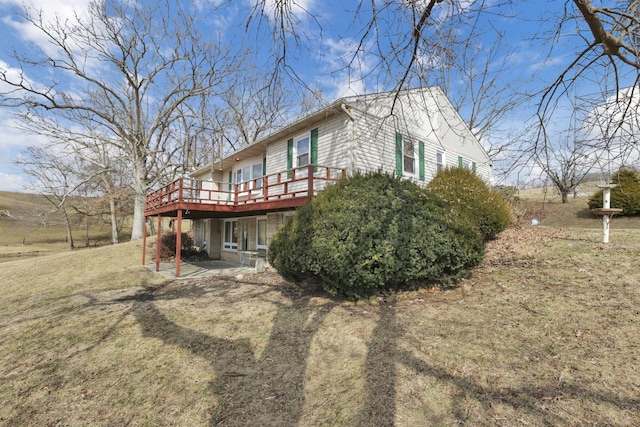 view of property exterior featuring a patio area, a yard, and a wooden deck