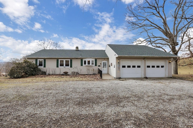 ranch-style home featuring a shingled roof, gravel driveway, a chimney, and an attached garage