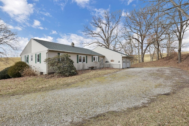 view of property exterior with driveway, an attached garage, a chimney, and roof with shingles