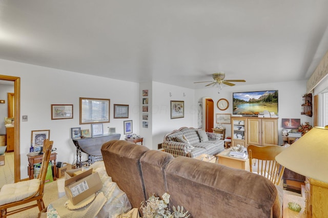 living area with arched walkways and ceiling fan