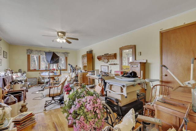 interior space with ceiling fan, ornamental molding, and wood finished floors