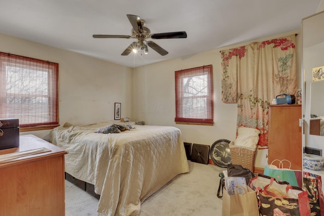 bedroom featuring multiple windows, a ceiling fan, and carpet flooring