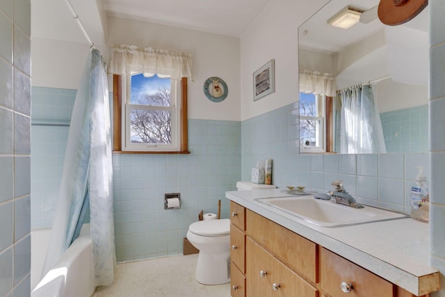 bathroom with tile walls, shower / bath combination with curtain, toilet, wainscoting, and vanity