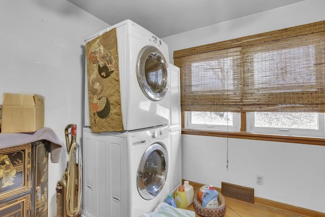 laundry area featuring stacked washer / drying machine, laundry area, and visible vents