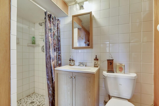 full bathroom featuring tile walls, backsplash, toilet, vanity, and tiled shower