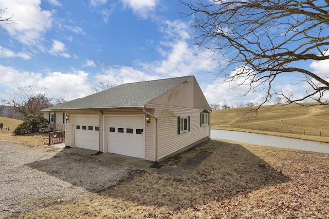 view of home's exterior with a shingled roof and a garage