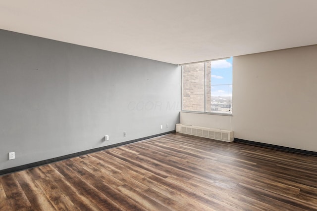 empty room featuring baseboards and wood finished floors