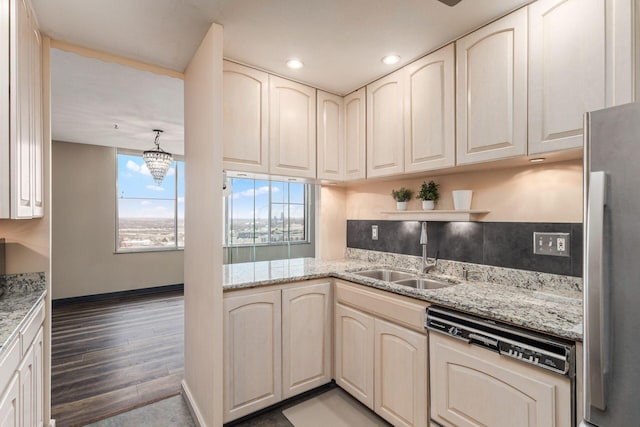 kitchen featuring paneled dishwasher, freestanding refrigerator, light stone countertops, light wood-type flooring, and a sink