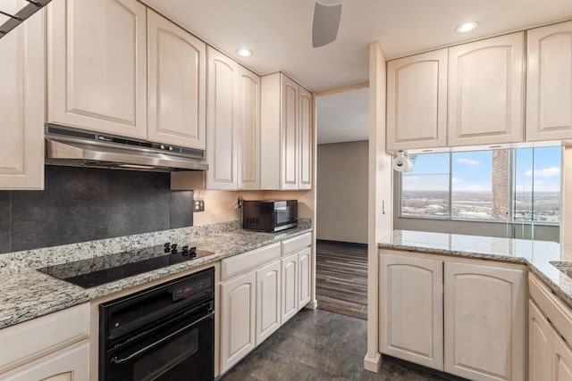 kitchen featuring black appliances, light stone counters, a ceiling fan, and under cabinet range hood