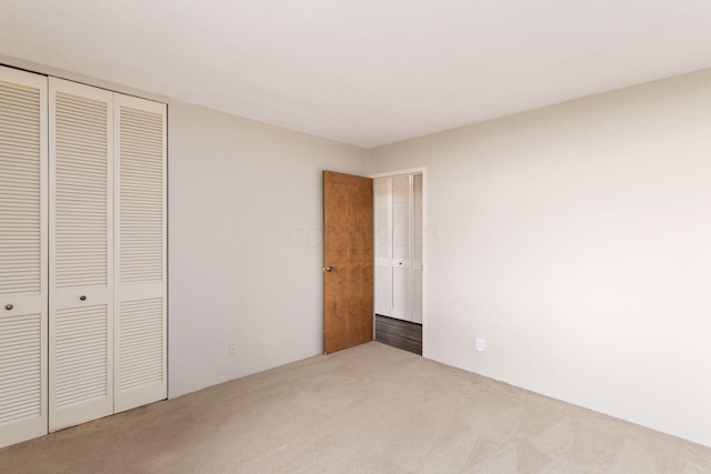 unfurnished bedroom with a closet and carpet flooring