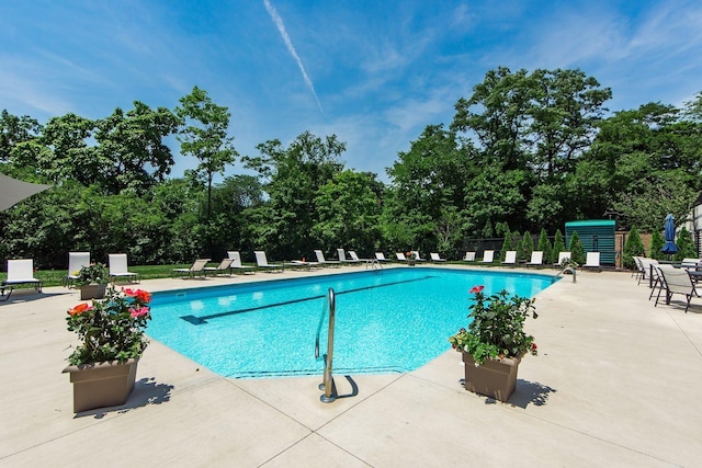 community pool with a patio and fence