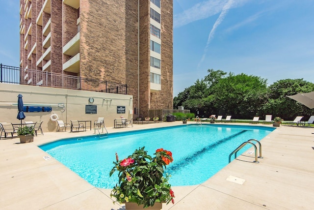 community pool featuring fence and a patio